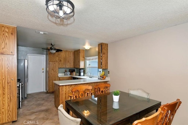 dining area with visible vents, a ceiling fan, and a textured ceiling