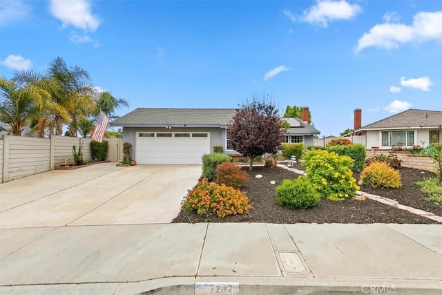 view of front facade featuring fence, an attached garage, stucco siding, concrete driveway, and solar panels