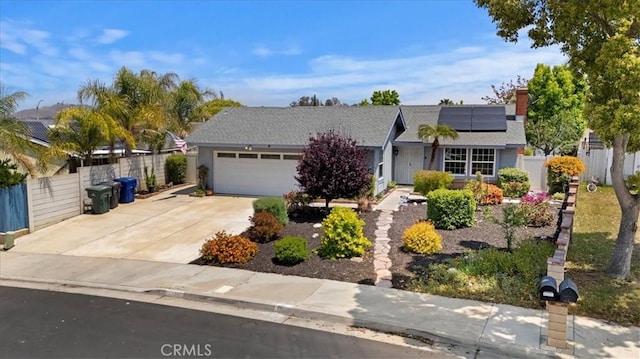 ranch-style home with concrete driveway, a garage, fence, and solar panels