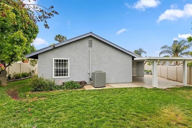 back of house with fence, a patio, stucco siding, central AC unit, and a lawn