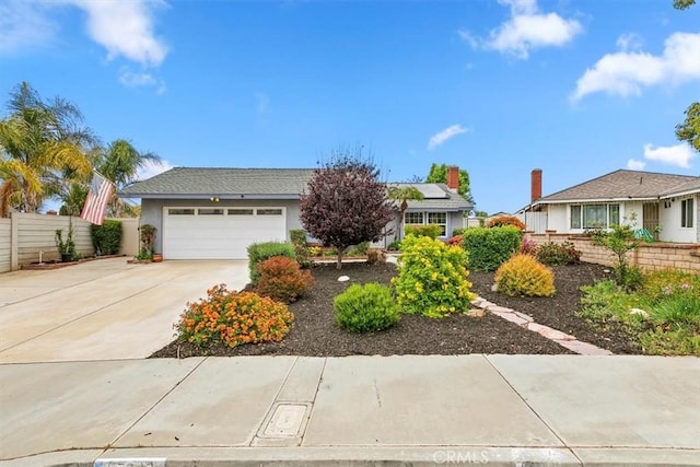 view of front of home with stucco siding, a garage, fence, and concrete driveway
