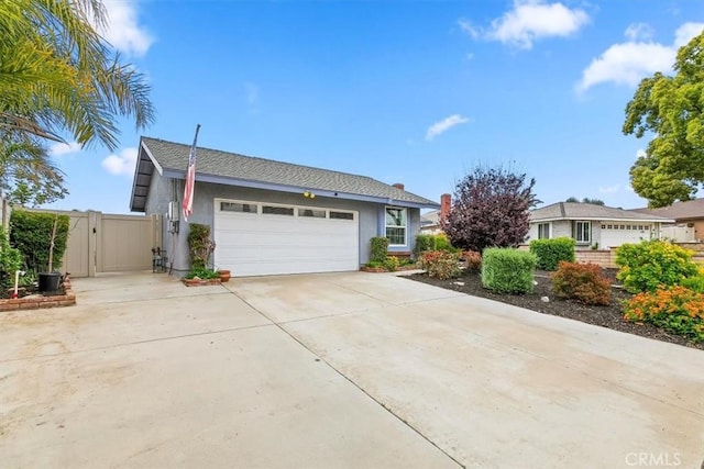 view of front of house with an attached garage, driveway, a gate, and stucco siding