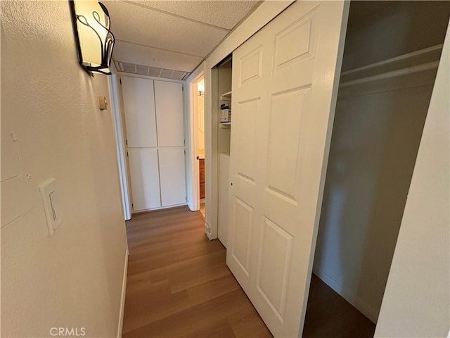 hallway featuring baseboards and wood finished floors