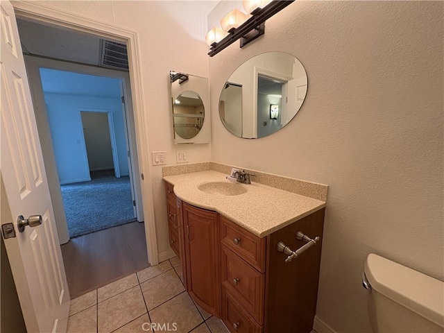 half bath with vanity, tile patterned floors, and toilet