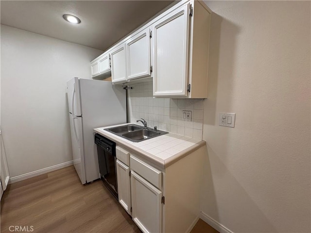 kitchen with decorative backsplash, baseboards, tile countertops, a sink, and dishwasher