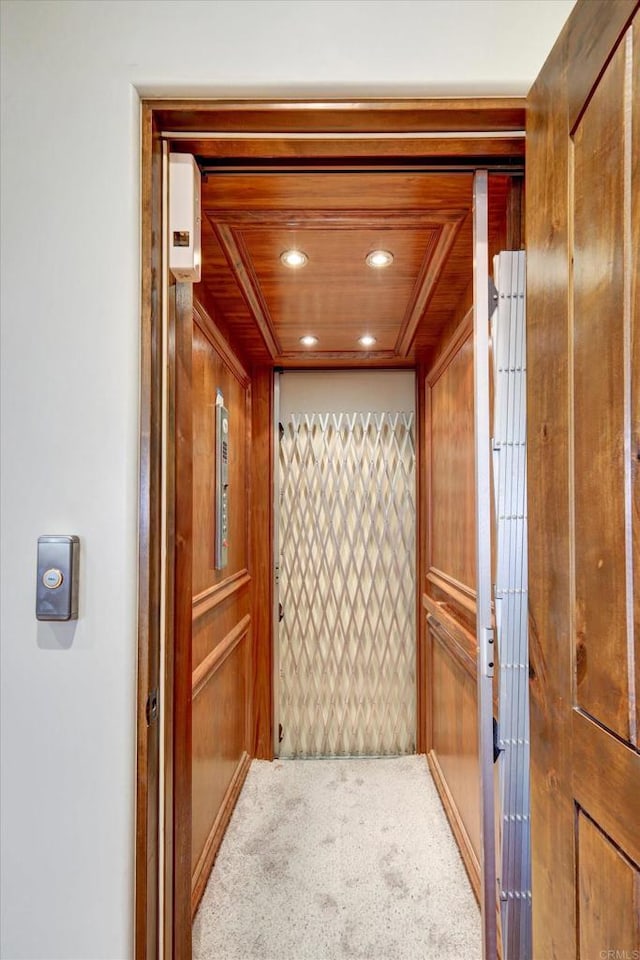 interior details with recessed lighting, carpet, elevator, and wooden walls