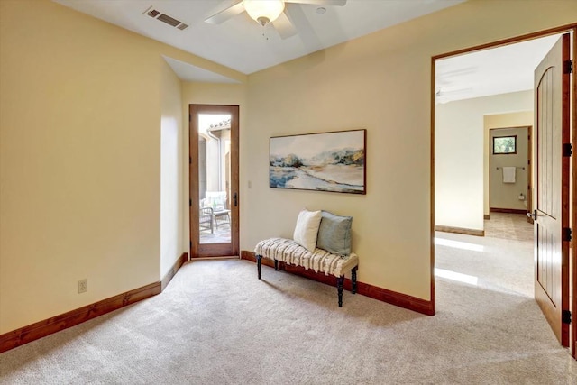 living area featuring carpet flooring, ceiling fan, visible vents, and baseboards