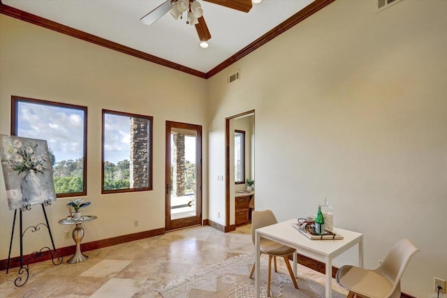 interior space with baseboards, ornamental molding, a ceiling fan, and visible vents