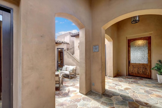 view of exterior entry with an outdoor hangout area, stucco siding, and a patio area