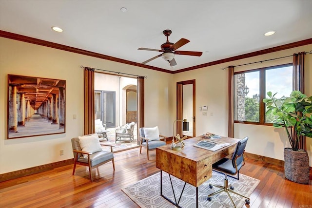 office area featuring wood-type flooring, a ceiling fan, baseboards, and crown molding