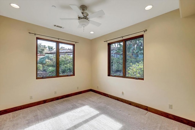 spare room with carpet floors, visible vents, and a healthy amount of sunlight