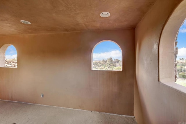 empty room with recessed lighting and arched walkways