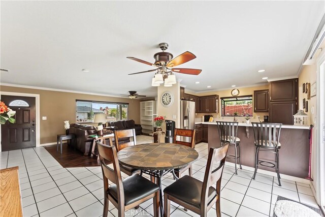 14901 Quill Cir, Huntington Beach, CA 92647 - dining area with healthy amount of natural light, a ceiling fan, light tile patterned floors, crown molding, and baseboards