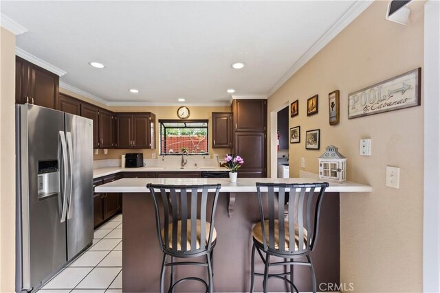 14901 Quill Cir, Huntington Beach, CA 92647 - kitchen with stainless steel fridge with ice dispenser, a sink, light countertops, a breakfast bar, and crown molding