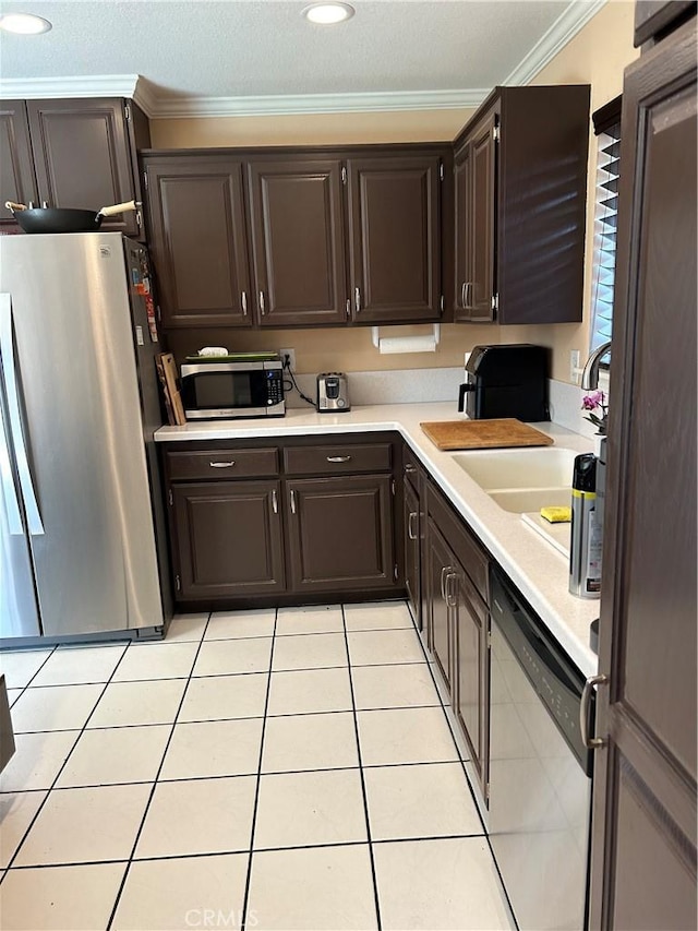 14901 Quill Cir, Huntington Beach, CA 92647 - kitchen with appliances with stainless steel finishes, ornamental molding, light countertops, dark brown cabinetry, and light tile patterned flooring