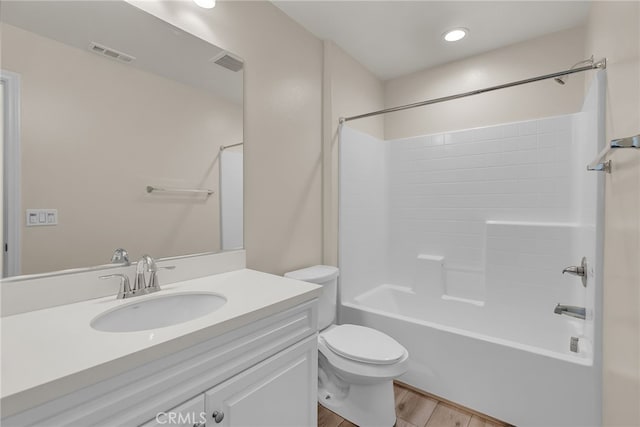 bathroom with vanity, toilet, wood finished floors, and visible vents