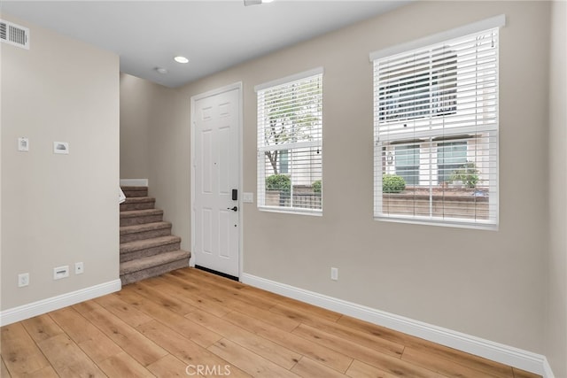 entryway with visible vents, wood finished floors, baseboards, stairway, and recessed lighting