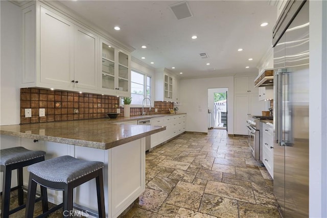 516 E Stocker St, Glendale, CA 91207 - kitchen featuring a peninsula, white cabinetry, recessed lighting, high end appliances, and glass insert cabinets