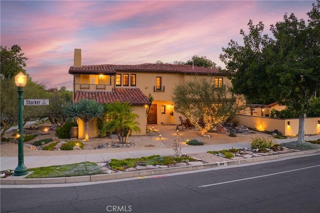 516 E Stocker St, Glendale, CA 91207 - mediterranean / spanish home featuring a chimney, a balcony, a tile roof, stucco siding, and fence