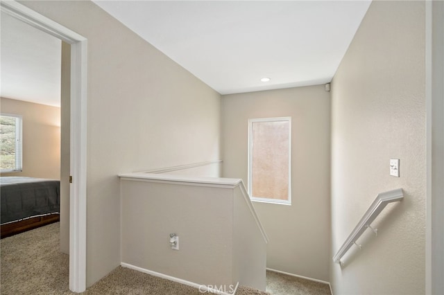 interior space with baseboards, carpet, and an upstairs landing