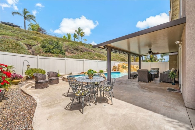 view of patio with outdoor dining area, a fenced backyard, an outdoor living space, a ceiling fan, and a fenced in pool