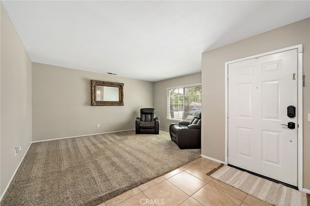 entryway featuring light tile patterned flooring, baseboards, visible vents, and light carpet