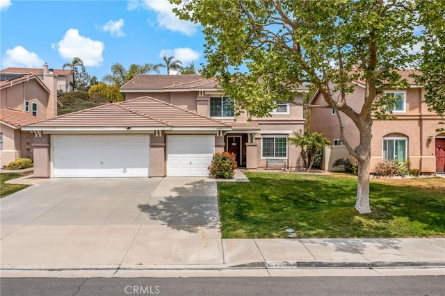 traditional-style house with concrete driveway, a garage, a front lawn, and stucco siding