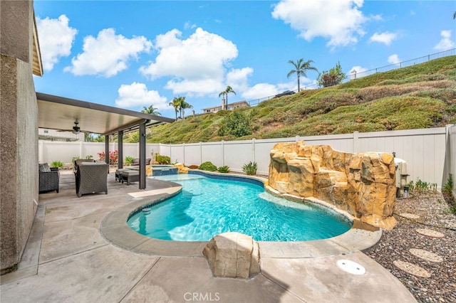 view of swimming pool with ceiling fan, a pool with connected hot tub, a fenced backyard, and a patio area