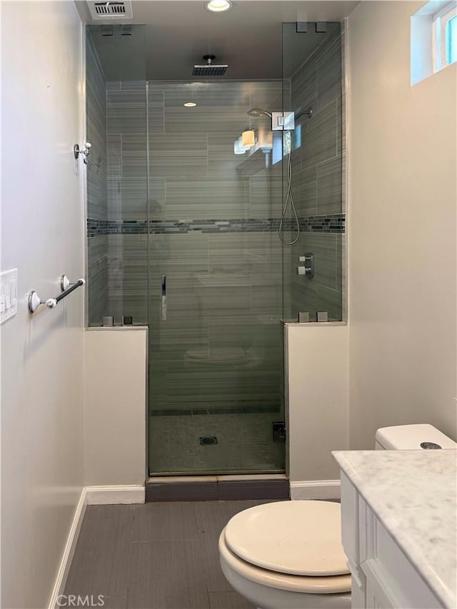 bathroom featuring vanity, a stall shower, visible vents, and toilet
