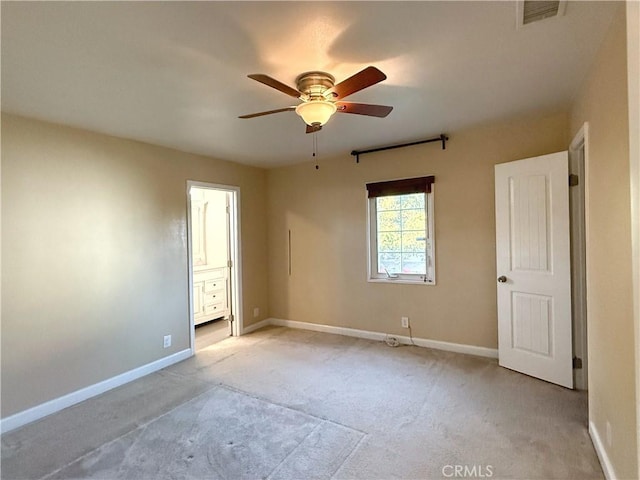 empty room featuring ceiling fan, visible vents, light carpet, and baseboards