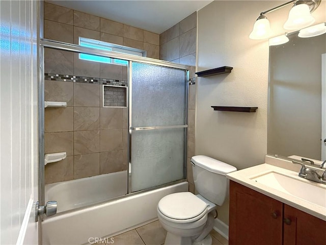 full bath with toilet, tile patterned floors, combined bath / shower with glass door, and vanity