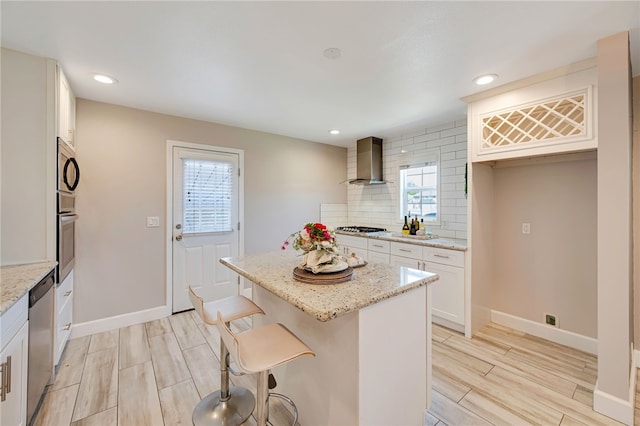 2030 N Keene Ave, Compton, CA 90059 - kitchen featuring wall chimney range hood, appliances with stainless steel finishes, wood finish floors, baseboards, and tasteful backsplash