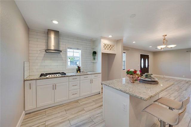 2030 N Keene Ave, Compton, CA 90059 - kitchen featuring wall chimney exhaust hood, stainless steel gas stovetop, wood finish floors, decorative backsplash, and recessed lighting
