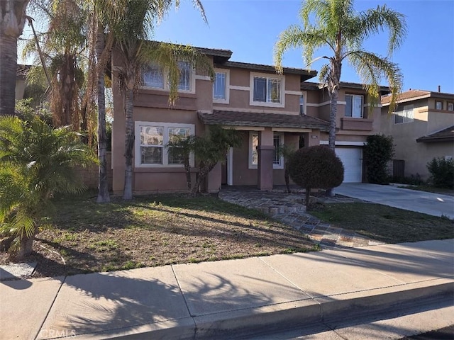view of front of home with a garage, stucco siding, and concrete driveway