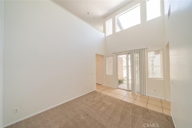 41044 Oak Creek Rd, Murrieta, CA 92562 - carpeted empty room with a towering ceiling, tile patterned floors, and baseboards
