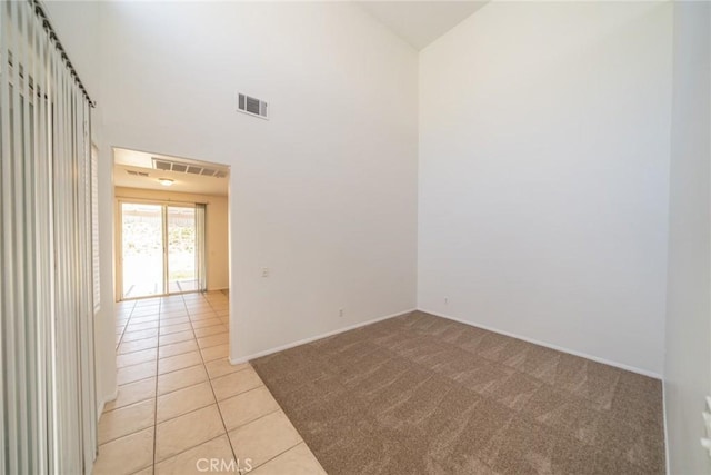 41044 Oak Creek Rd, Murrieta, CA 92562 - empty room with light colored carpet, light tile patterned floors, baseboards, and a high ceiling