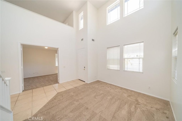 41044 Oak Creek Rd, Murrieta, CA 92562 - carpeted empty room featuring tile patterned floors, a high ceiling, and baseboards