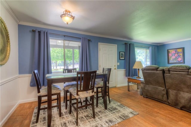 dining space featuring plenty of natural light, wainscoting, and wood finished floors