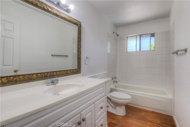 bathroom featuring vanity, wood finished floors, bathtub / shower combination, and toilet