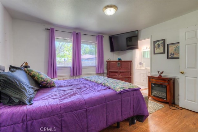 bedroom featuring light wood-type flooring and ensuite bath