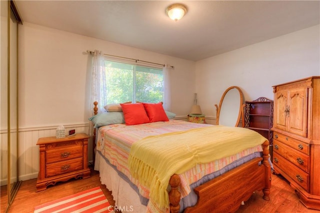 bedroom featuring light wood-style floors and wainscoting