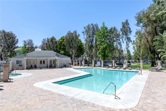 community pool featuring fence and a patio area