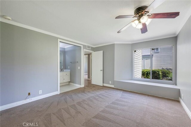spare room with carpet flooring, crown molding, baseboards, ceiling fan, and a smoke detector