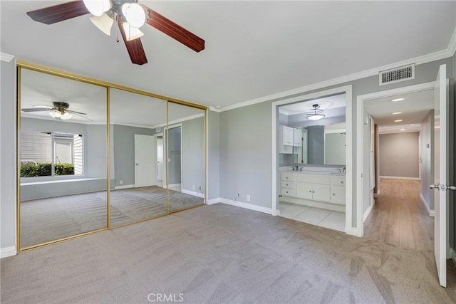 unfurnished bedroom featuring light carpet, baseboards, and ornamental molding