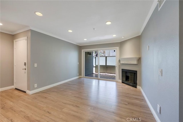 unfurnished living room featuring crown molding, light wood finished floors, recessed lighting, baseboards, and a fireplace