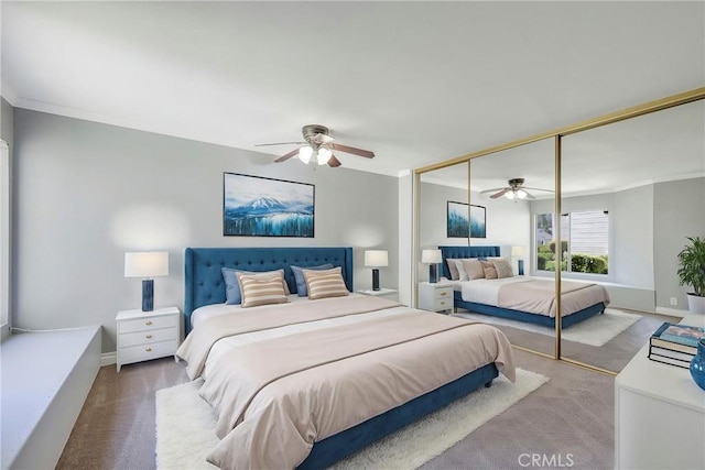 bedroom featuring carpet flooring, a closet, ceiling fan, baseboards, and ornamental molding