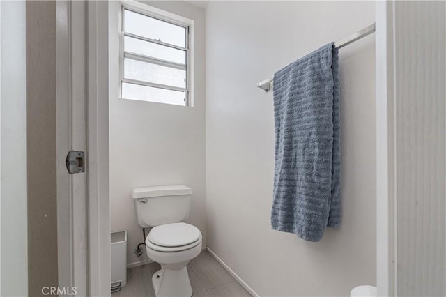 bathroom featuring baseboards and toilet