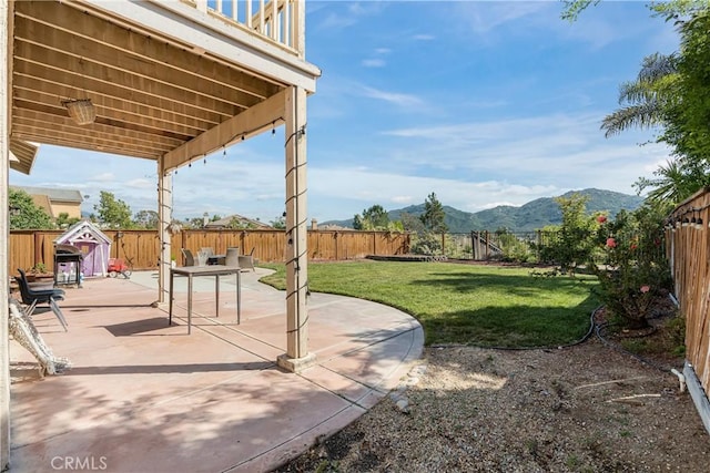 view of yard with a patio, a fenced backyard, and a mountain view