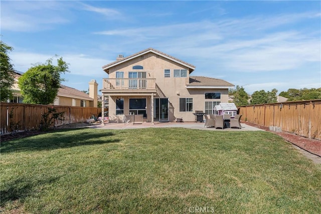 back of house featuring a lawn, a patio, a balcony, and a fenced backyard