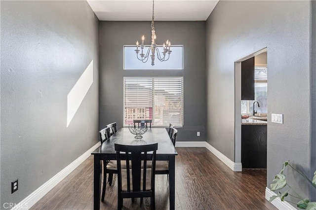 dining area with dark wood-style flooring, baseboards, a notable chandelier, and plenty of natural light